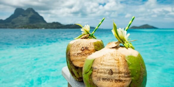 2 noix de coco avec écrit "Bora bora" face au lagon, avec le Mont Otemanu derrière