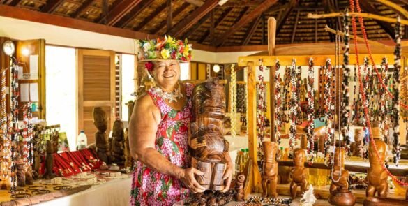 boutique d'artisanat à Nuku Hiva. Femme portant un tiki en bois. Exposition de multiples colliers en graines
