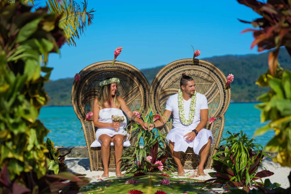 couple assis sur des fauteuils Pomaré pour une cérémonie de mariage traditionnel polynésien - Voyages de noces en Polynésie Française