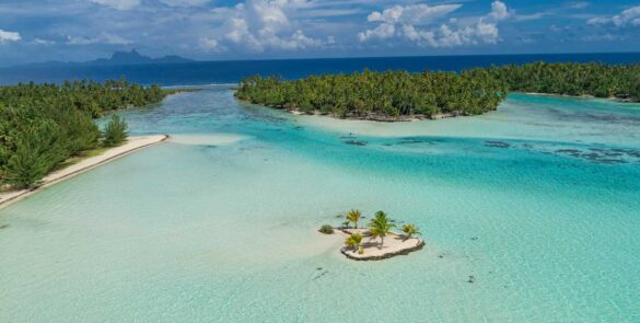 Vue aérienne sur le lagon de Taha'a. Océan et île de Bora Bora en arrière plan.