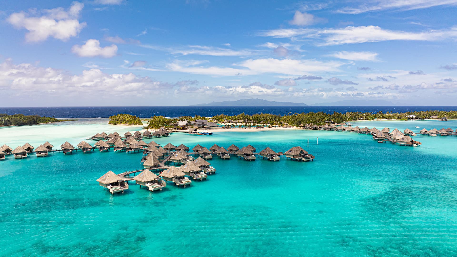 Hôtel the Westin Bora Bora Resort & Spa 5***** - vue aérienne sur le lagon et les villas sur pilots, et le récif en arrière plan.