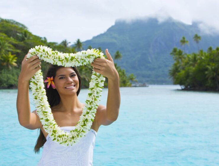Femme polynésienne à Bora Bora portant collier de fleurs de Tiare pour souhaiter la bienvenue.