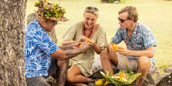 homme polynésien tatoué partageant des fruits locaux avec des touristes