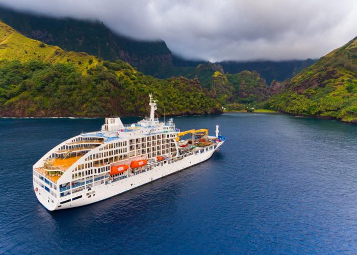 Vue aérienne de l'Aranui arrivant dans la baie des Vierges à Fatu Hiva - Croisières en Polynésie à bord de l'Aranui