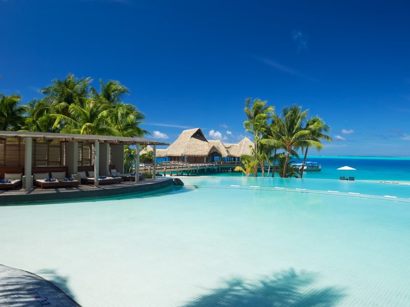 Hôtel Conrad Bora Bora Nui 5* à Bora Bora. Vue sur la piscine, le patio et le lagon