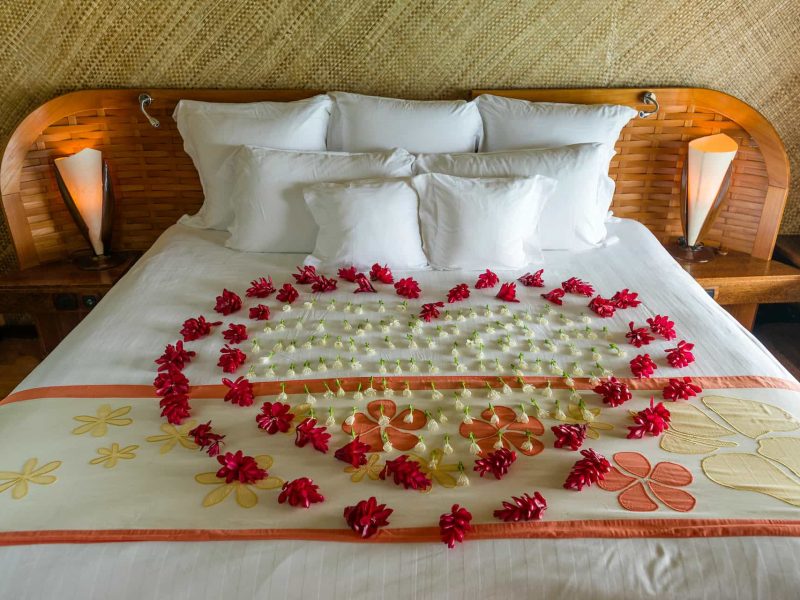 Hôtel Intercontinental Le Moana 4* à Bora Bora. Intérieur d'un bungalow avec une décoration floral sur le lit.