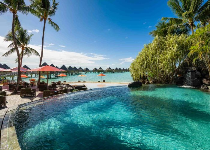 Hôtel Intercontinental Moana Bora Bora 4*. Vue sur la piscine et le bar Vini Vini. Bungalows sur Pilotis et lagon en arrière plan