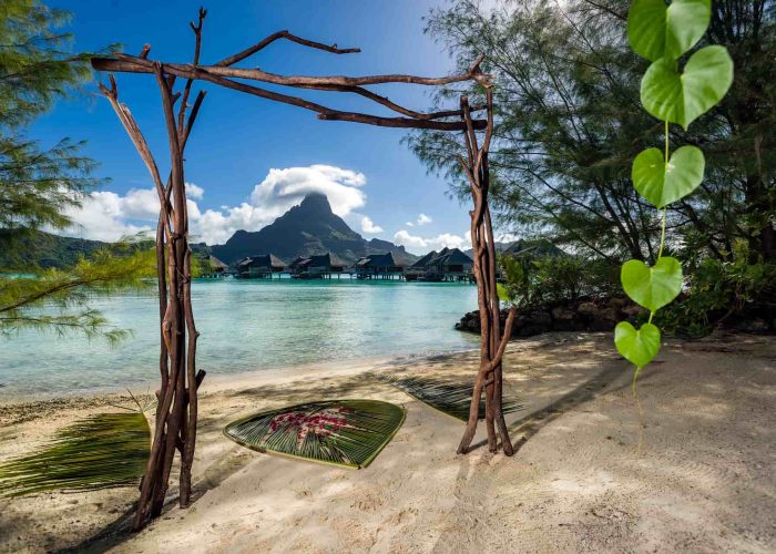 Hôtel Intercontinental Bora Bora Resort & Thalasso Spa 5*. Décoration pour une cérémonie de mariage sur la plage. Lagon, Villas sur Pilotis et Mont Otemanu.