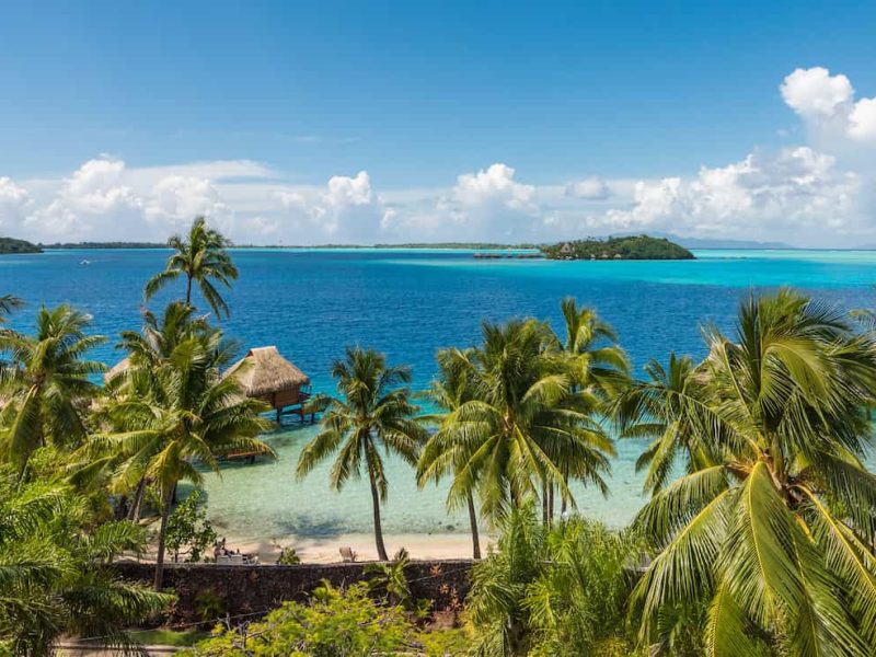 Hôtel Maitai Polynesia 3*** - vue aérienne depuis la colline, avec lagon et bungalows sur pilotis. Motu en arrière plan.