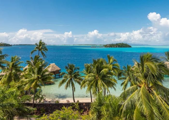 Hôtel Maitai Polynesia 3*** - vue aérienne depuis la colline, avec lagon et bungalows sur pilotis. Motu en arrière plan.