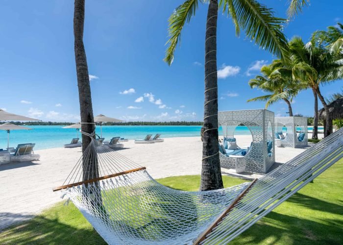 subtiles-tahiti-bora-bora-hotel-st-regis-1©st-regis-bora-bora Hôtel St Regis 5* à Bora Bora - Plage principale, transats, hamacs et cocotiers.