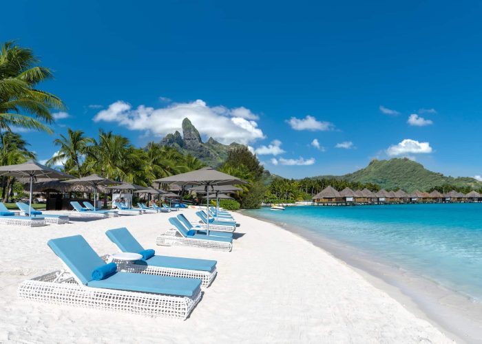 Hôtel St Regis 5* à Bora Bora - Plage principale, transats, lagon et Mont Otemanu en arrière plan.