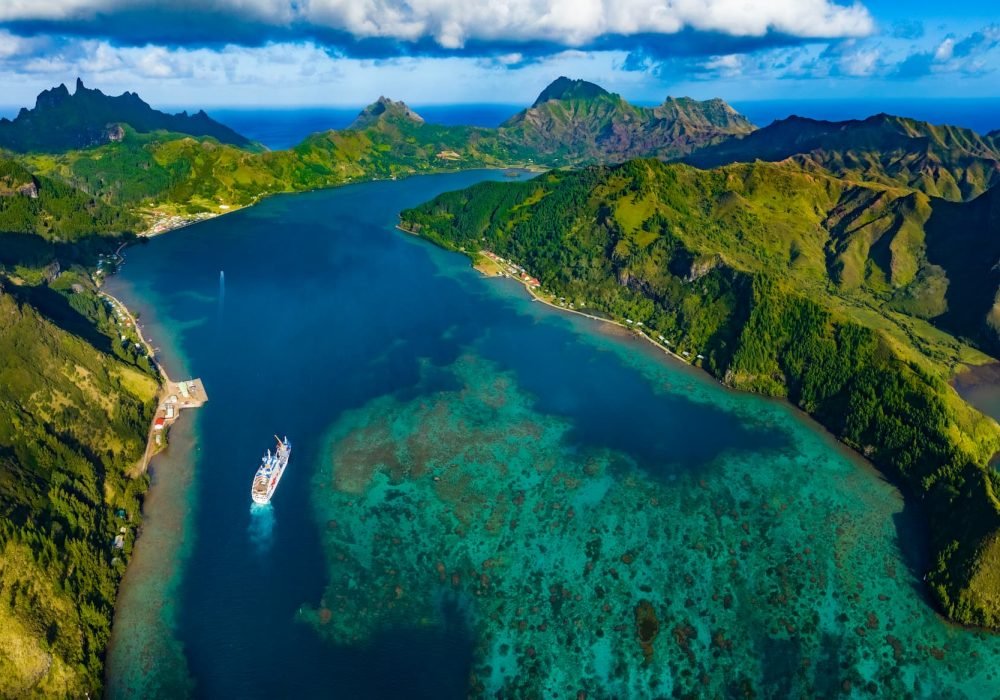 cargo-mixte Aranui V naviguant dans une baie dans l'archipel des Australes