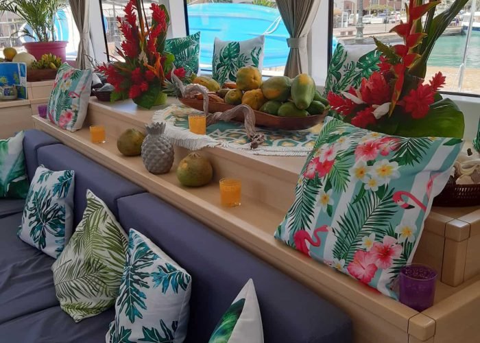 subtiles-tahiti-croisiere-catamaran-dream-yacht-charter-15©dream-yacht-charter Croisière Dream Yacht Charter - Intérieur d'un catamaran Lagoon 620. Canapé et décoration tropicale.