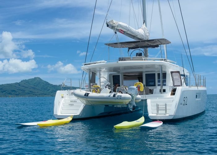subtiles-tahiti-croisiere-catamaran-tahiti-yacht-charter-7©patrick-lefebvre Croisière privée Tahiti Yacht Charter - poupe d'un catamaran Lagoon 52 Solea, avec bateau annexe, kayaks et paddles.