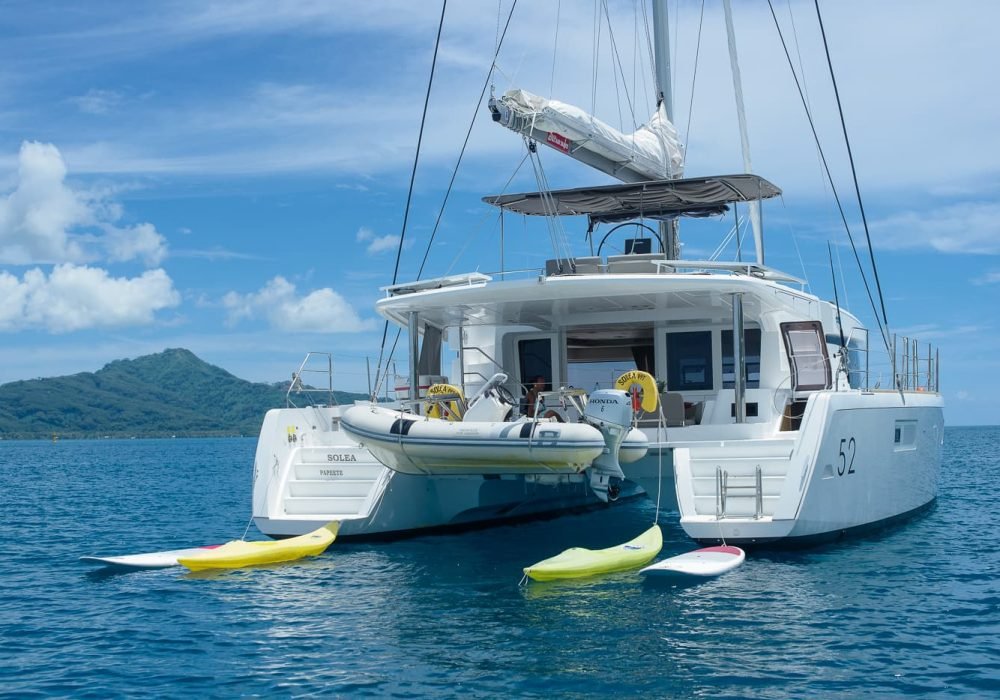 Croisière privée Tahiti Yacht Charter - poupe d'un catamaran Lagoon 52 Solea, avec bateau annexe, kayaks et paddles.