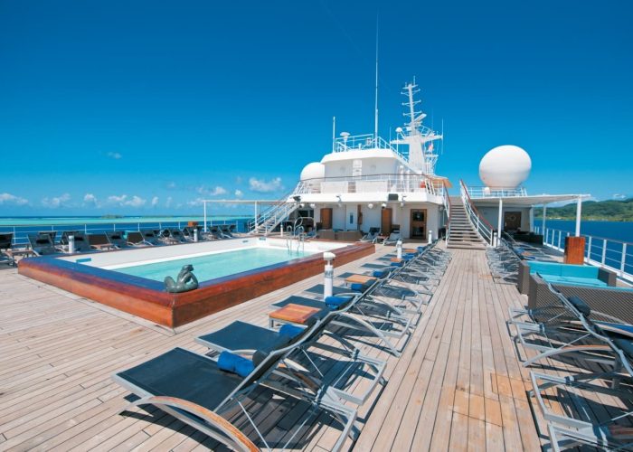 Croisière Paul Gaugauin - Ponant. Vue sur l'extérieur du deck supérieur avec piscine et transats.