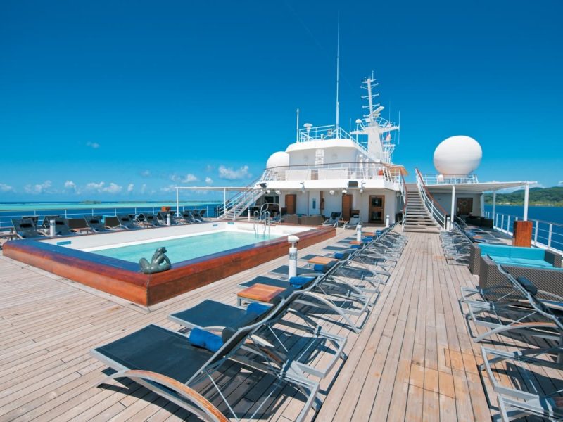 Croisière Paul Gaugauin - Ponant. Vue sur l'extérieur du deck supérieur avec piscine et transats.