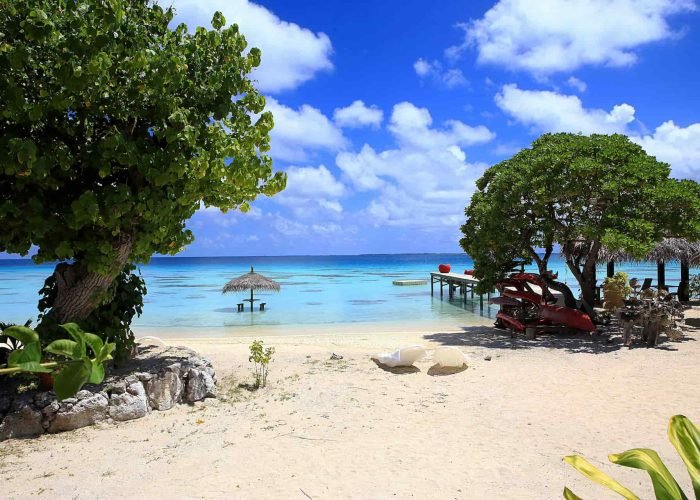 subtiles-tahiti-fakarava-pension-havaiki-lodge-1©havaiki-lodge Pension Havaiki Lodge à Fakakara. Vue sur la plage et le lagon. Ponton et table et parasol dans l'eau.