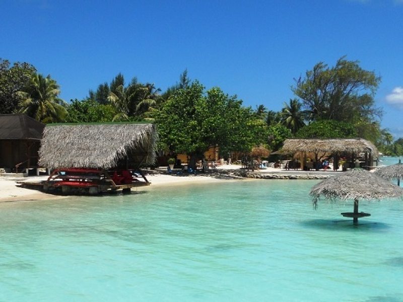 Pension Havaiki Lodge ) Fakarava - vue depuis le lagon sur la plage, avec ses paillotes dans l'eau