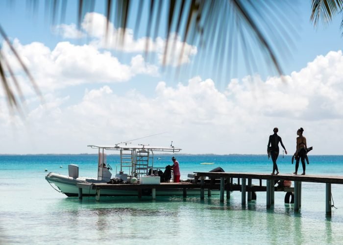 deux apnéistes marchant sur un ponton pour rejoindre un bateau à Fakarava