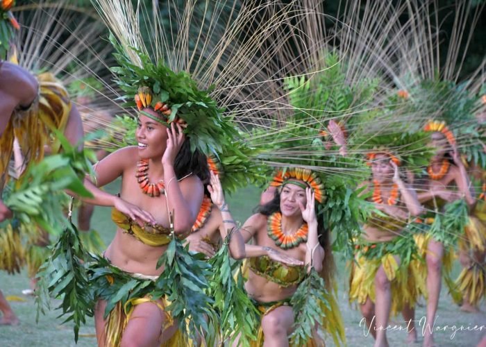 femmes polynésiennes en tenue traditionnelle en train de danser pour le Heiva i Tahiti Festival