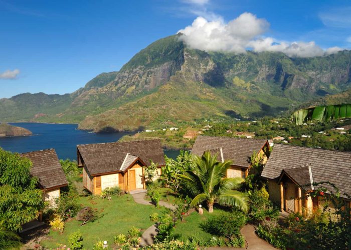 Hôtel Hanakee lodge 3* à Hiva Oa, aux îles Marquises. Vue aérienne des bungalows avec vue sur la baie d'Atuona et montagne en arrière plan.