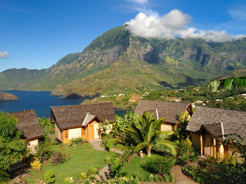 Hôtel Hanakee lodge 3* à Hiva Oa, aux îles Marquises. Vue aérienne des bungalows avec vue sur la baie d'Atuona et montagne en arrière plan.