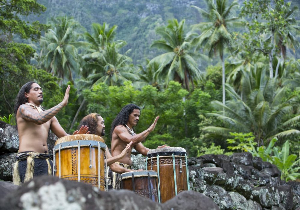 trois musiciens marquisiens jouant du pahu dans la forêt de Hiva Oa