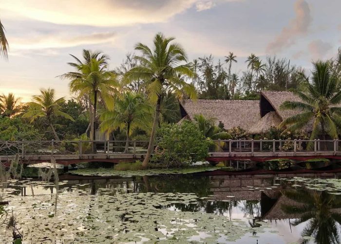 Hôtel Maitai Lapita Village 3* à Huahine. Vue générale sur le lac et les bungalows, au coucher du soleil.