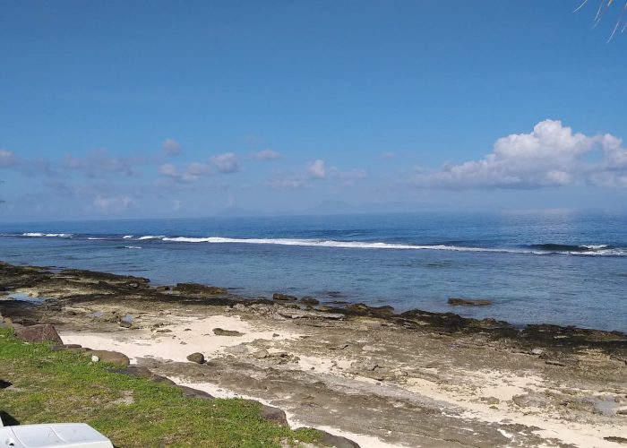 Pension Fare Maeva à Huahine - Bord de lagon avec plateau corallien et transats.