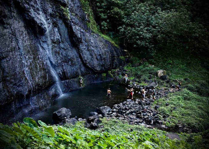 Activité en famille à Moorea - Vue aérienne d'une famille se baignant dans une cascade lors d'une excursion.