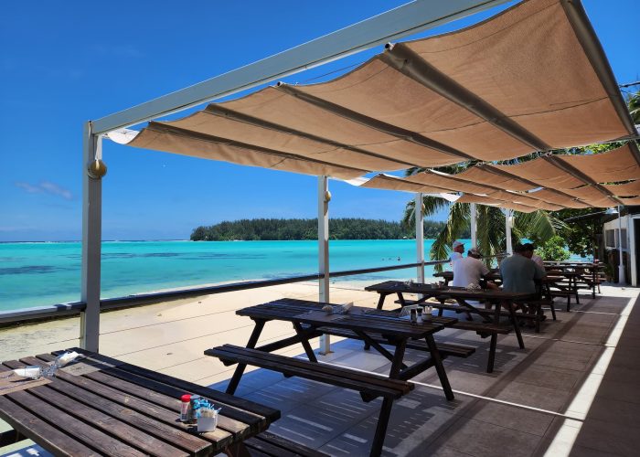 Hôtel Hibiscus 2* à Moorea. Pergola du restaurant "sunset" en bord de plage et vue sur le lagon turquoise.