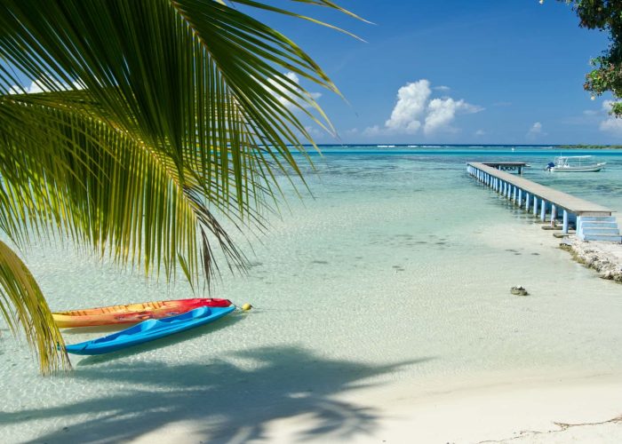 Hôtel Les Tipaniers 2* à Moorea. Vue sur la plage, le lagon et le ponton de l'hôtel. 2 kayaks au premier plan.