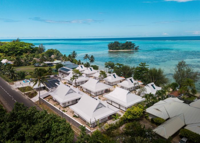 Hôtel Niu Beach à Moorea. Vue aérienne sur les bungalows de l'hôtel. Lagon turquoise et motu en arrière plan.