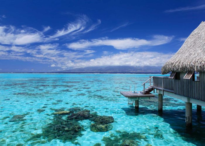 Hôtel Sofitel Kia Ora Moorea Beach Resort 5* à Moorea. Vue depuis le lagon sur un Bungalow Luxury sur Pilotis Horizon. Lagon turquoise et patate de corail.