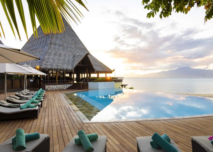 Hôtel Sofitel Kia Ora Moorea Beach Resort 5*. Au coucher du soleil, Vue piscine, lagon et au loin l'île de Tahiti.