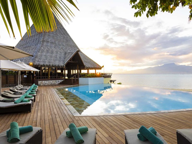 Hôtel Sofitel Kia Ora Moorea Beach Resort 5*. Au coucher du soleil, Vue piscine, lagon et au loin l'île de Tahiti.