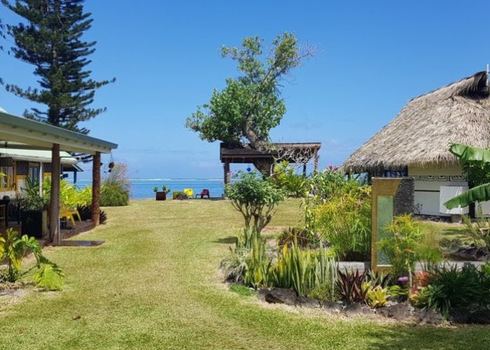 Pension Linareva Moorea Beach Resort à Moorea. Vue générale sur le jardin de la pension avec bungalows de part et d'autre d'un chemin menant au lagon.