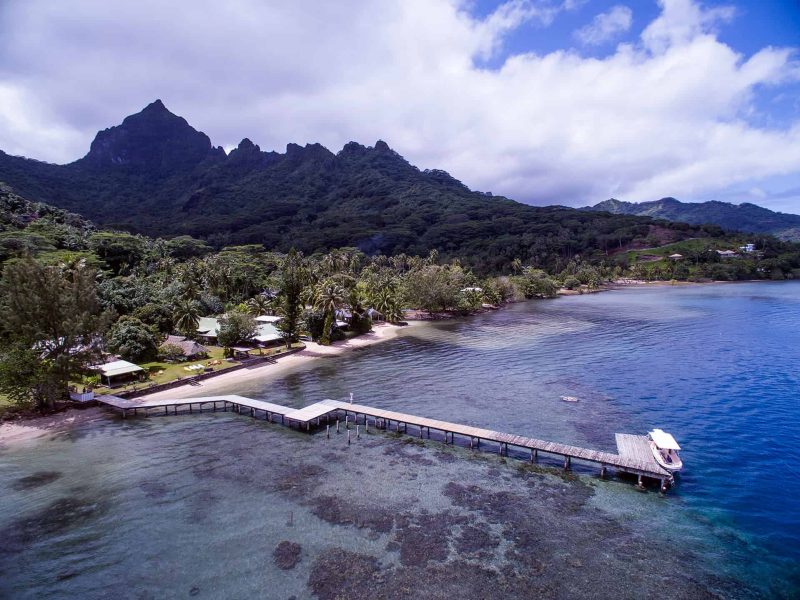 Pension Linareva Moorea Beach Resort à Moorea. Vue aérienne générale et la pension et son ponton. Montagnes de Moorea en arrière plan.