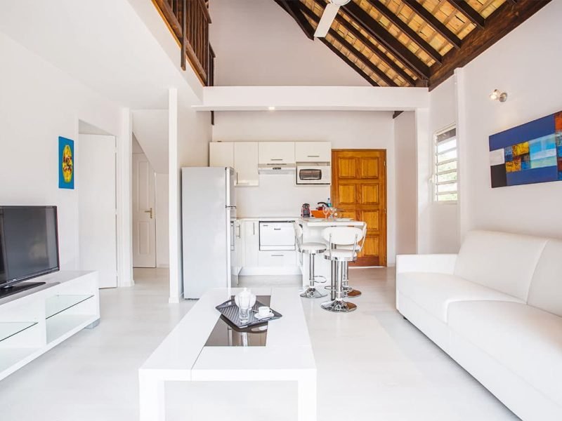 Résidence Moorea Sunset Beach. Intérieur d'un bungalow avec salon et coin cuisine.