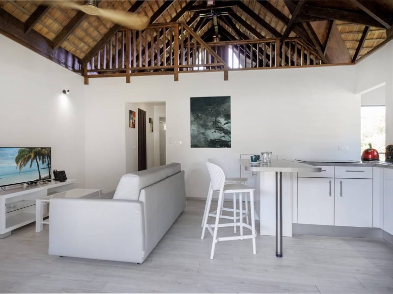 Résidence Moorea Sunset Beach. Vue de l'intérieur d'un Bungalow avec sa cuisine, son salon et sa mezzanine.