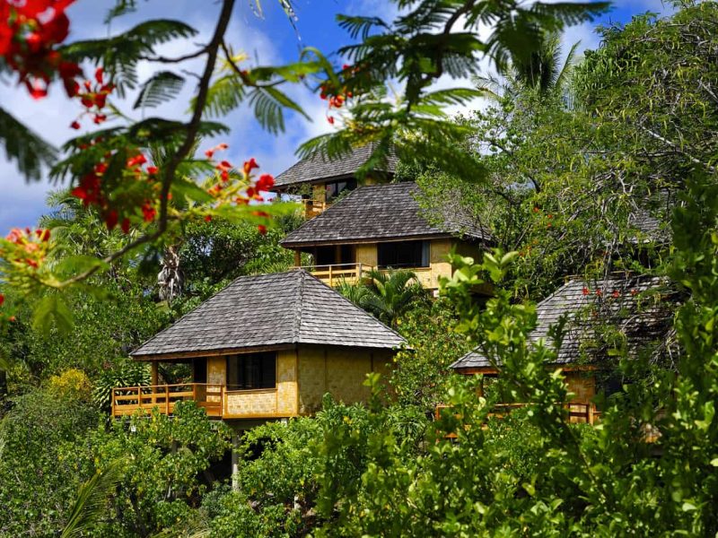 Hôtel Le Nuku Hiva by Pearl Resorts 3*. Vue extérieure sur les bungalows à flanc de colline, entourés de végétations.