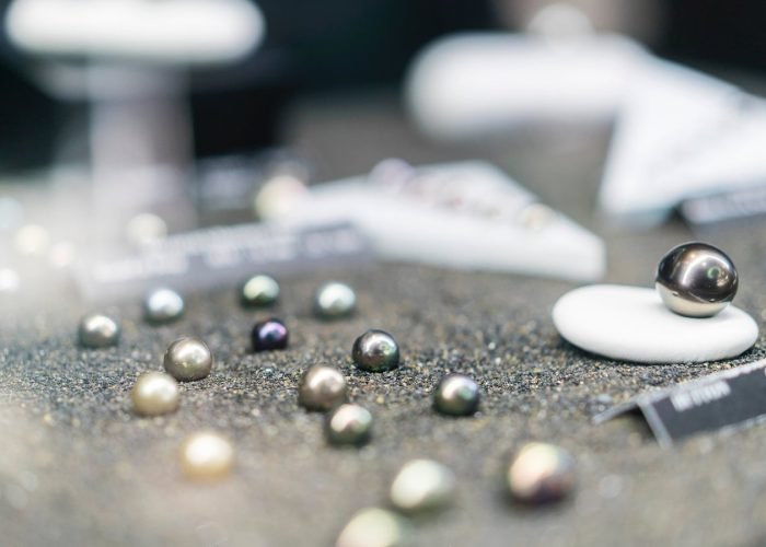 perles de tahiti multicolores exposées sur du sable noir