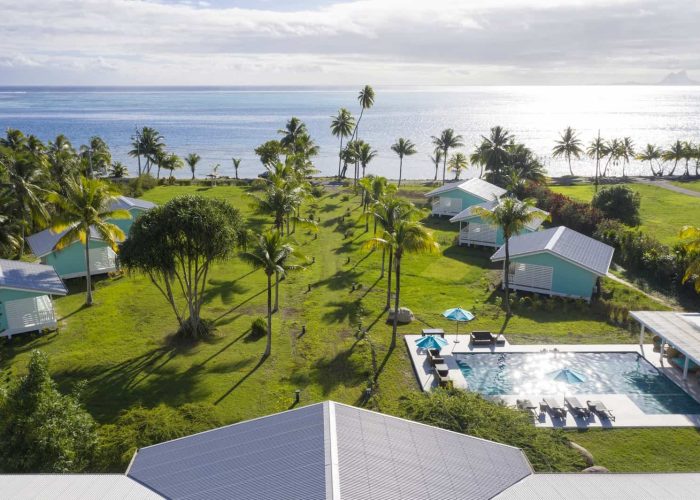 Hôtel Raiatea Lodge 3 à Raiatea. Vue aérienne générale sur le jardin de l'hôtel, la piscine et les bungalows. Lagon en arrière plan.