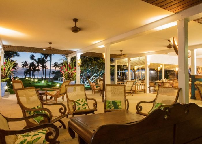 Hôtel Raiatea Lodge 3* à Raiatea. Salon de l'hôtel avec vue sur le jardin et le lagon en arrière plan.