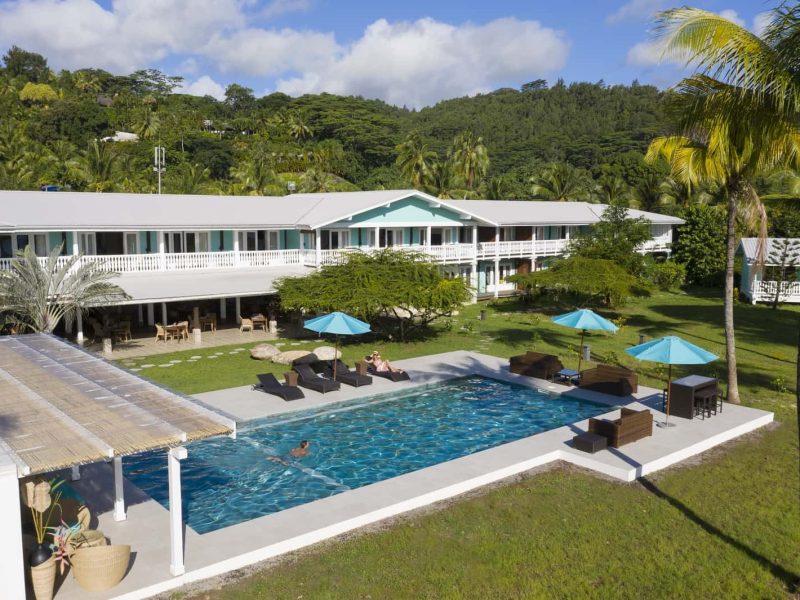 Hôtel Raiatea Lodge 3* à Raiatea - vue sur la piscine, le bâtiment principal de style colonial et la montagne verdoyante en arrière plan