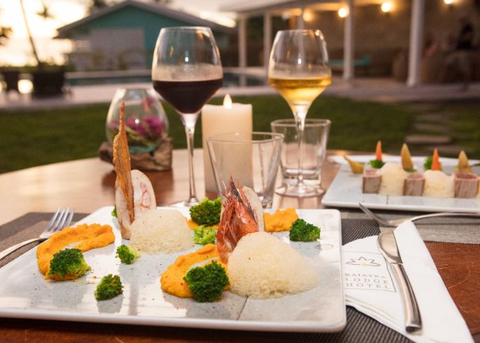 Hôtel Raiatea Lodge 3* à Raiatea. Table avec repas gastronomique et verres de vin.