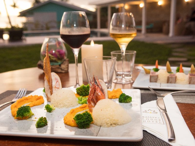 Hôtel Raiatea Lodge 3* à Raiatea. Table avec repas gastronomique et verres de vin.