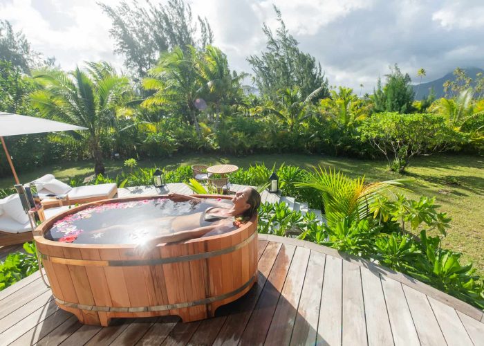 Motu Nao Nao, île privée à Raiatea. Femme se relaxant dans un bain nordique sur la terrasse d'une villa.